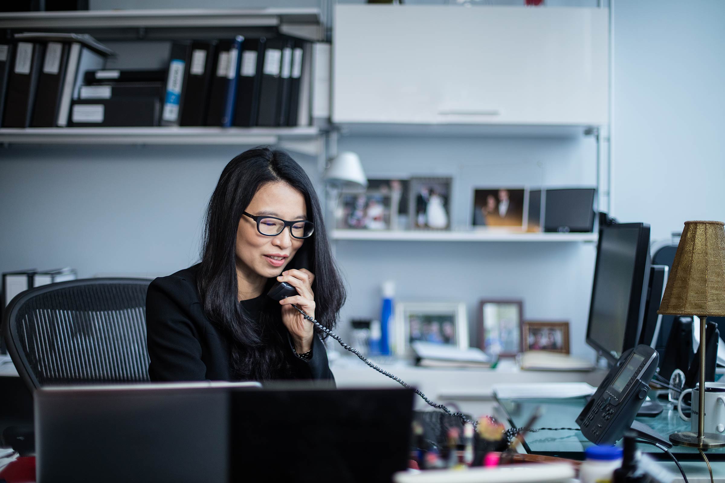 An Asian woman executive on the phone in her New York City Office 