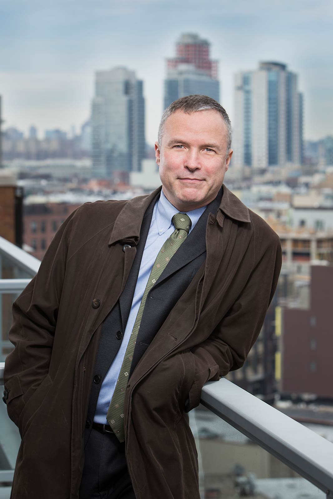 Casual outdoor portrait of doctor on balcony with New York skyline in background