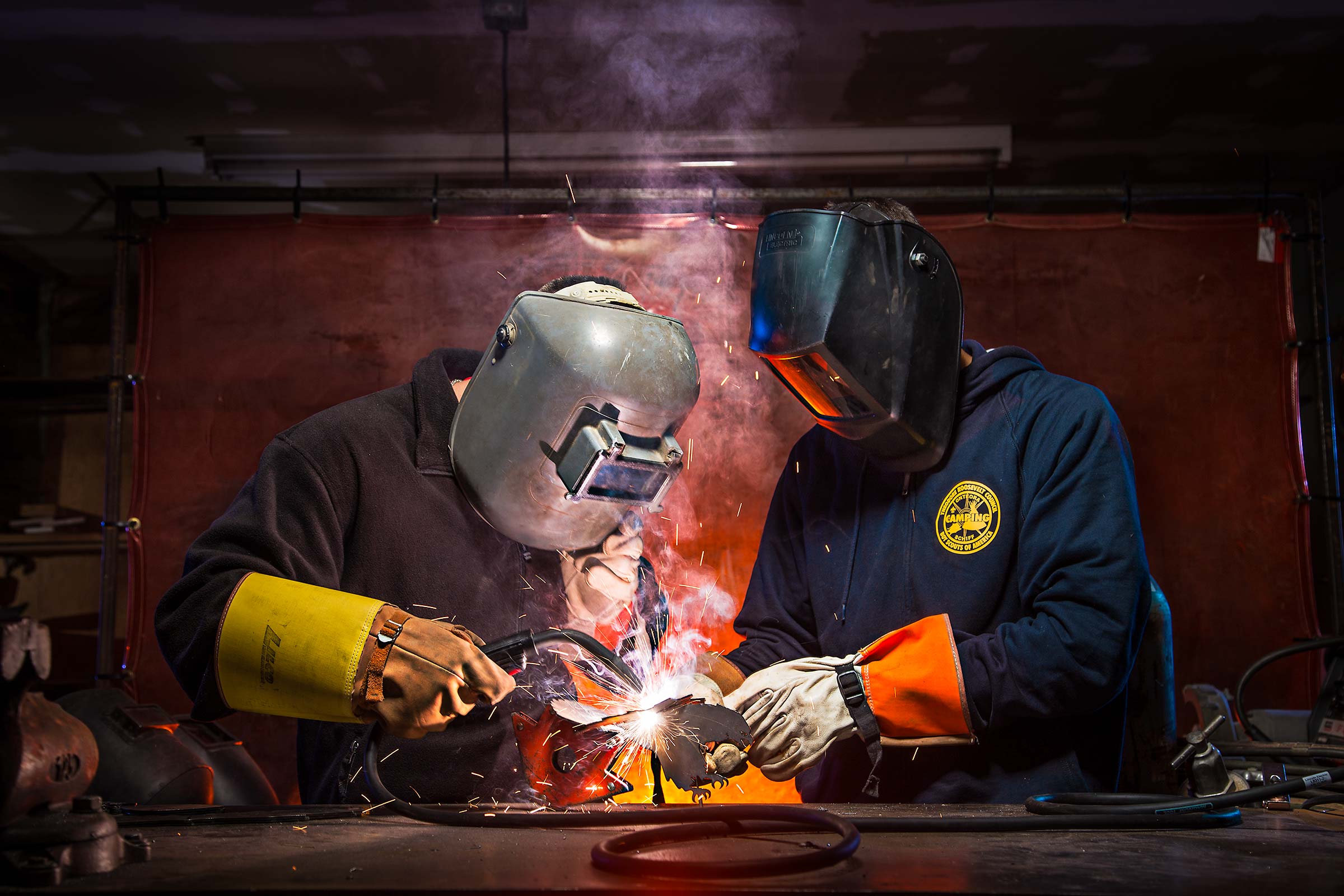 Two Young men learning to weld steel at a Boyscouts of America Camp