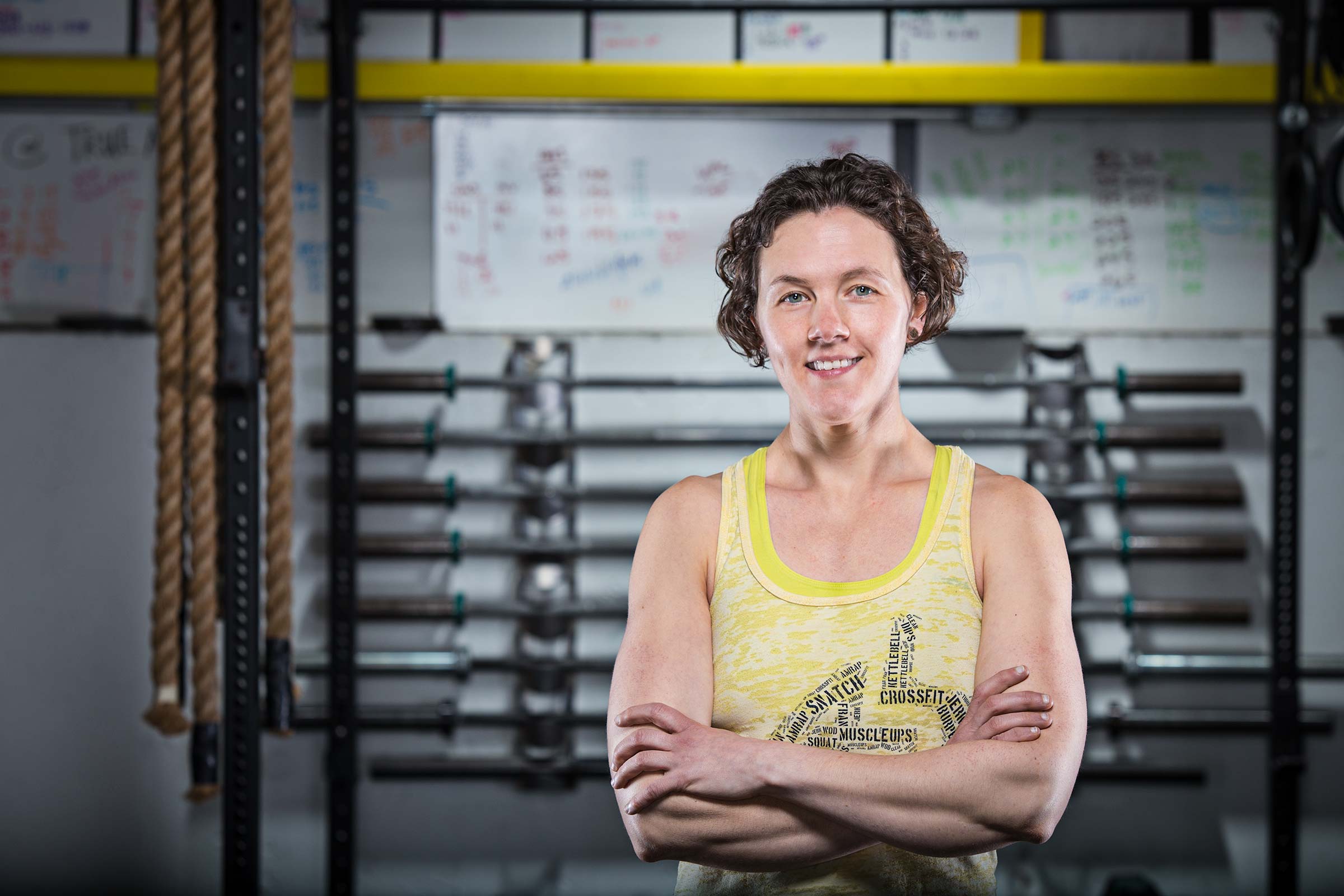 Upbeat portrait of a female crossfit trainer in front of equipment in Connecticut gym