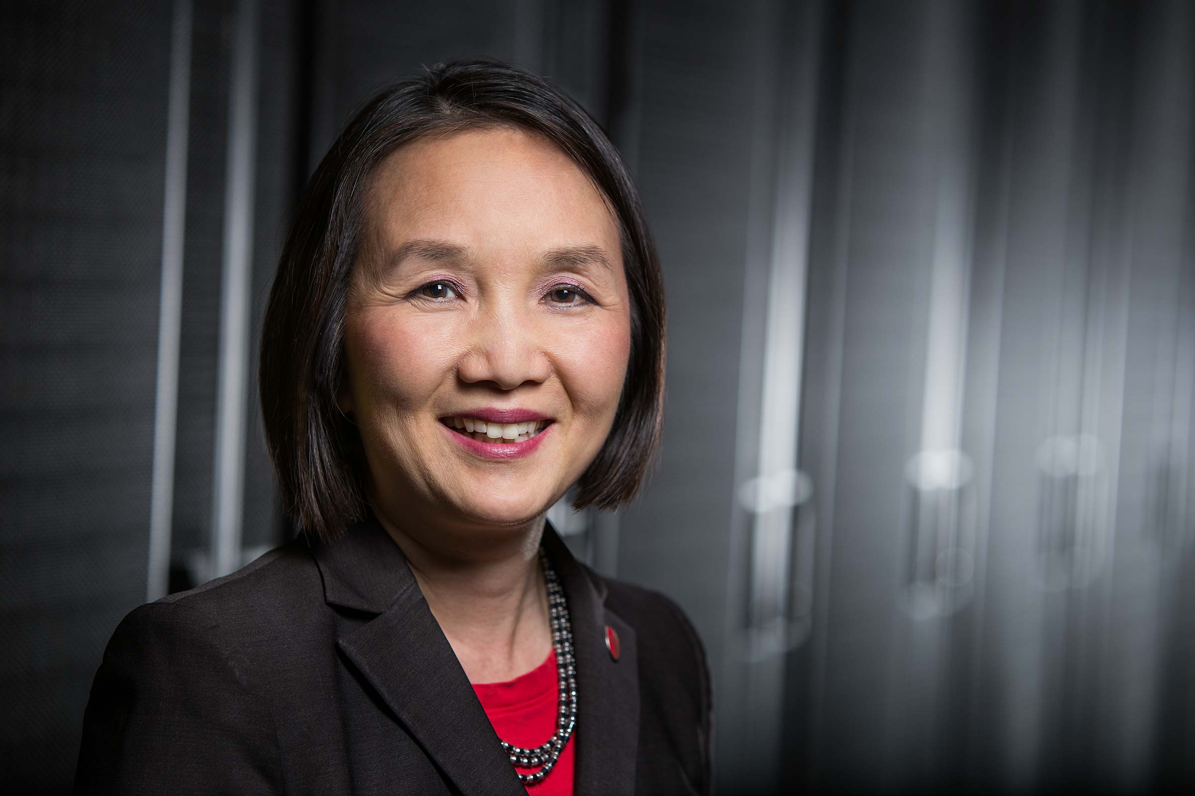 dramatic closeup portriat of an Asian woman technology director in a server room 