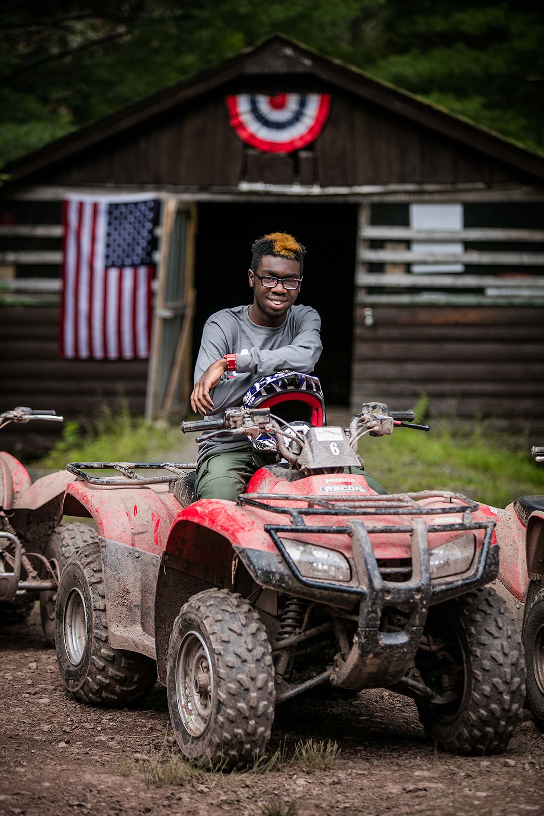 Portrait of smiling African american male teenager on ATV at Camp in New York