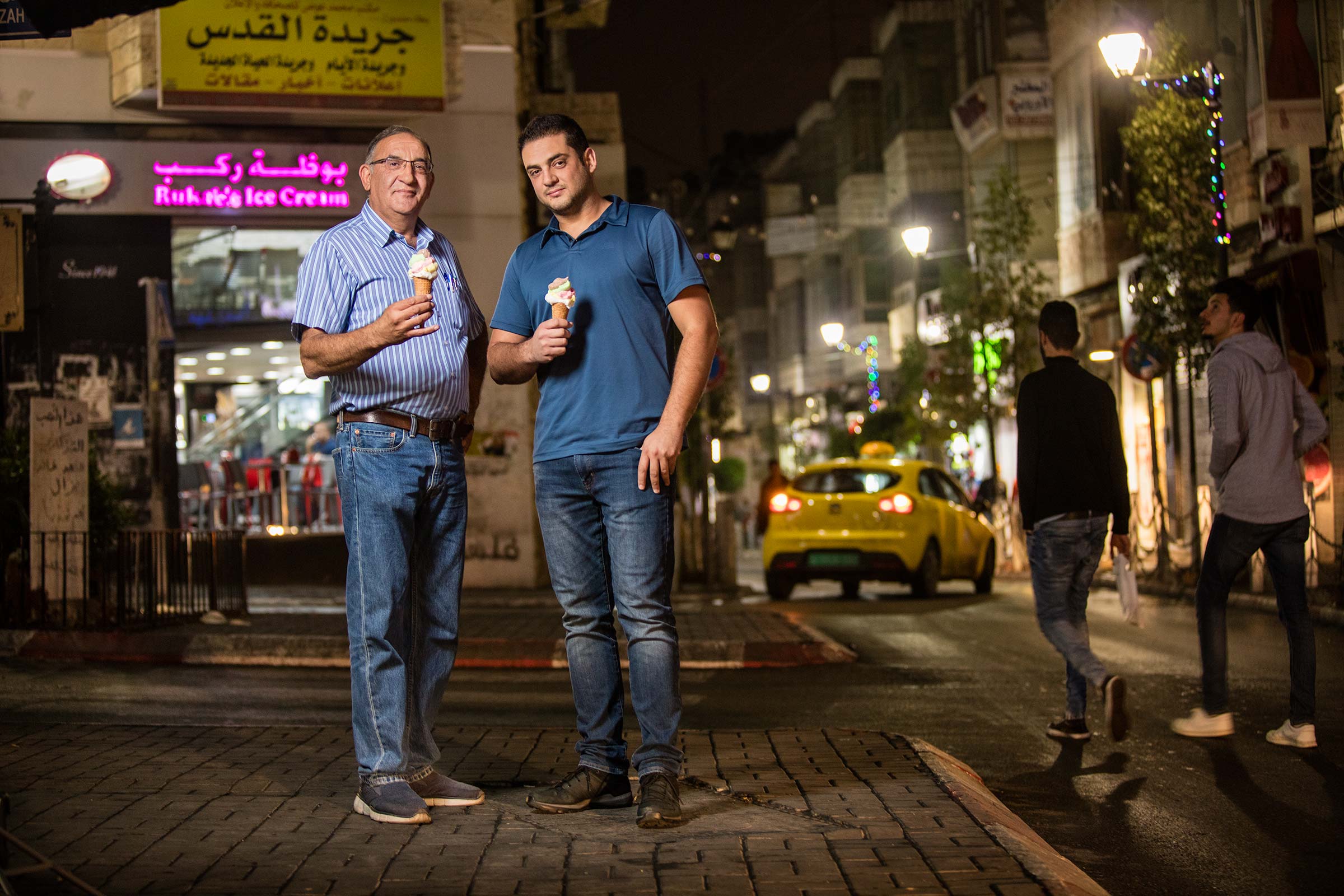 night portrait of father and son coowners of small business in Palestine