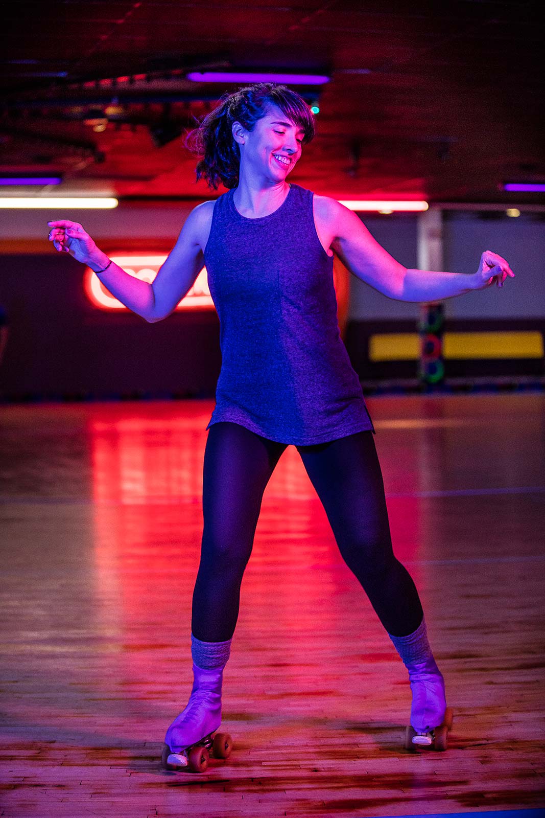 A vibrant colorful portrait of a young woman dancing on roller skates at a rink in Connecticut