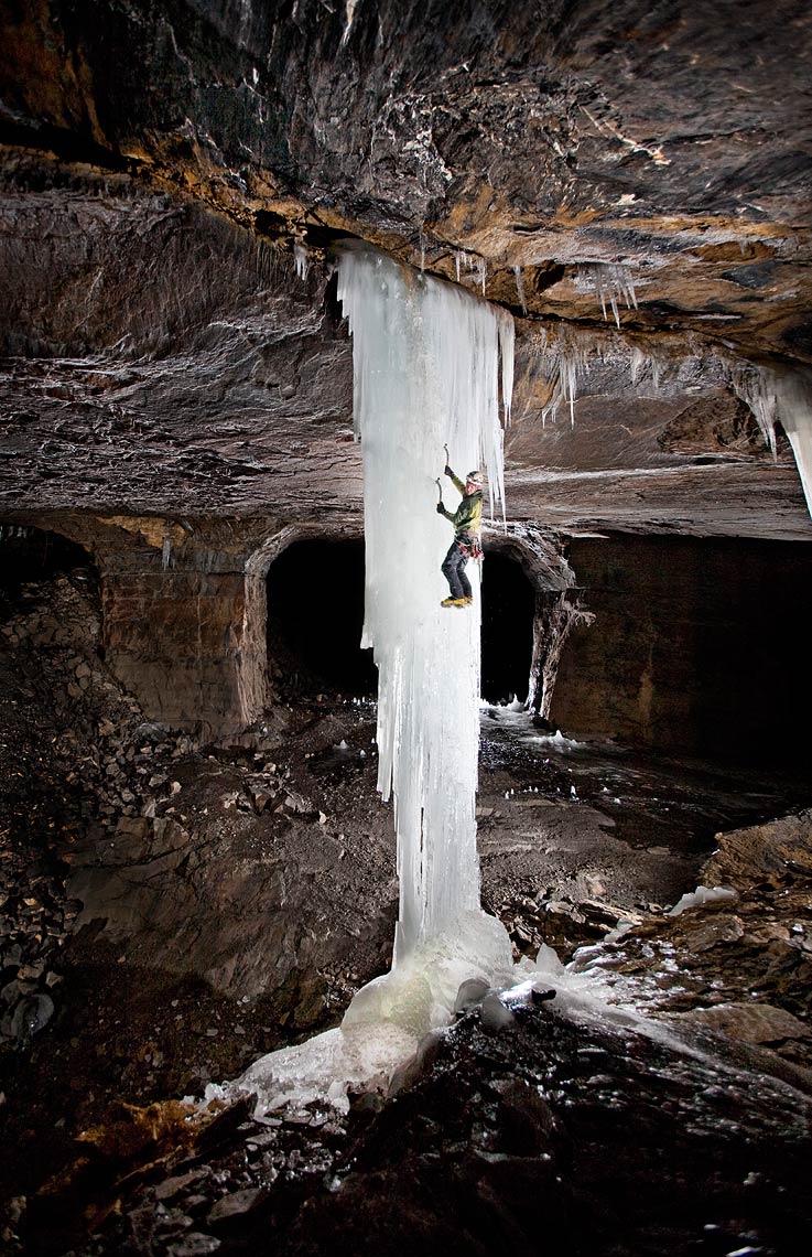 A professional ice climber ascends a frozen pillar in a subterranean mine in New York