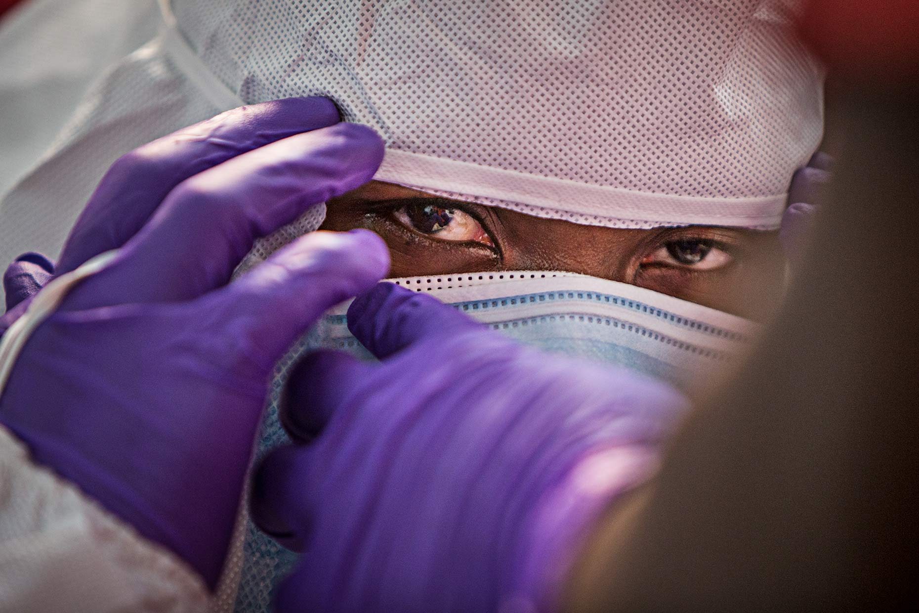 A doctor in An Ebola hospital dons protective gear before entering the ward