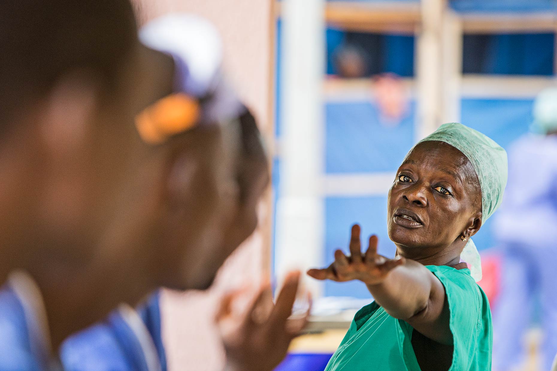 A lead nurse passionately commanding her staff at a meeting in a West African Ebola center