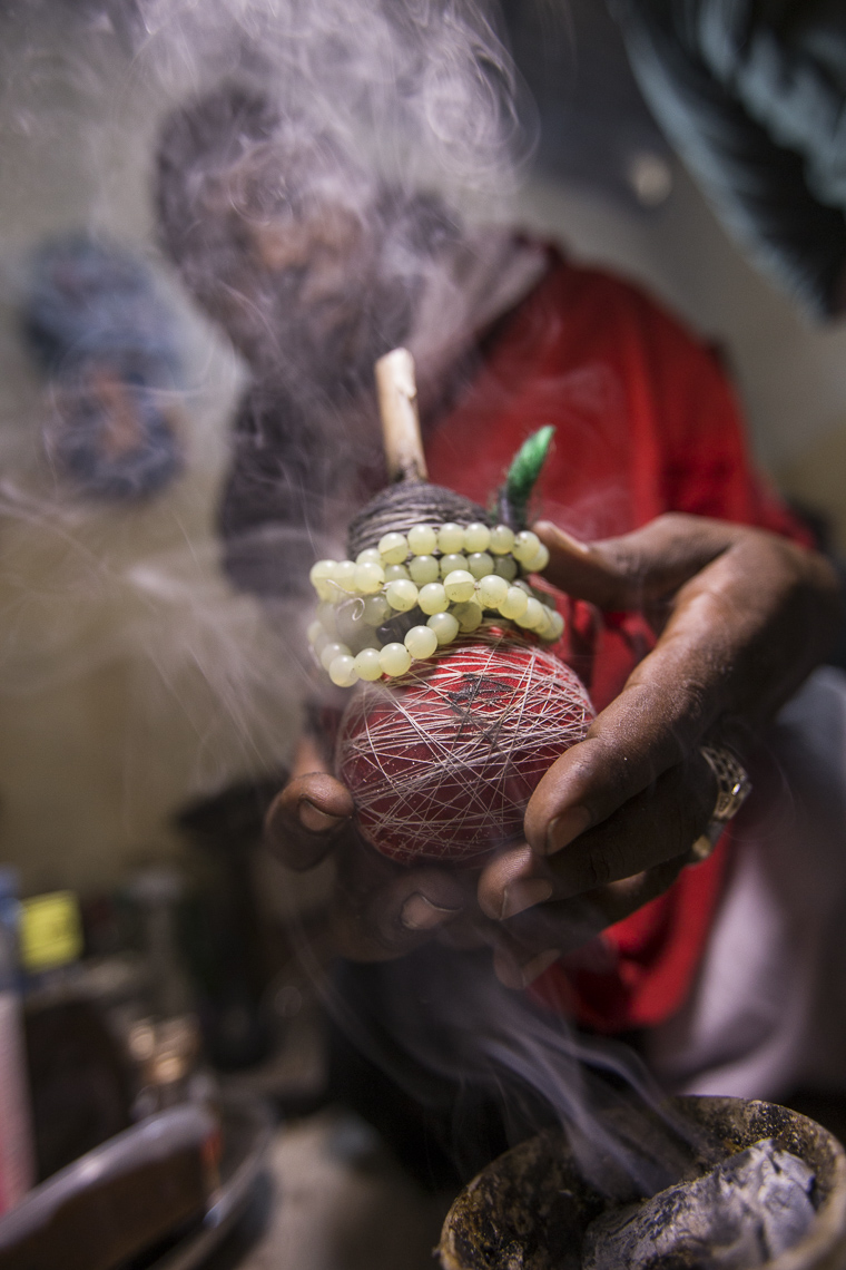 A witchdoctor uses smoke to transfer magical properties during a ritual