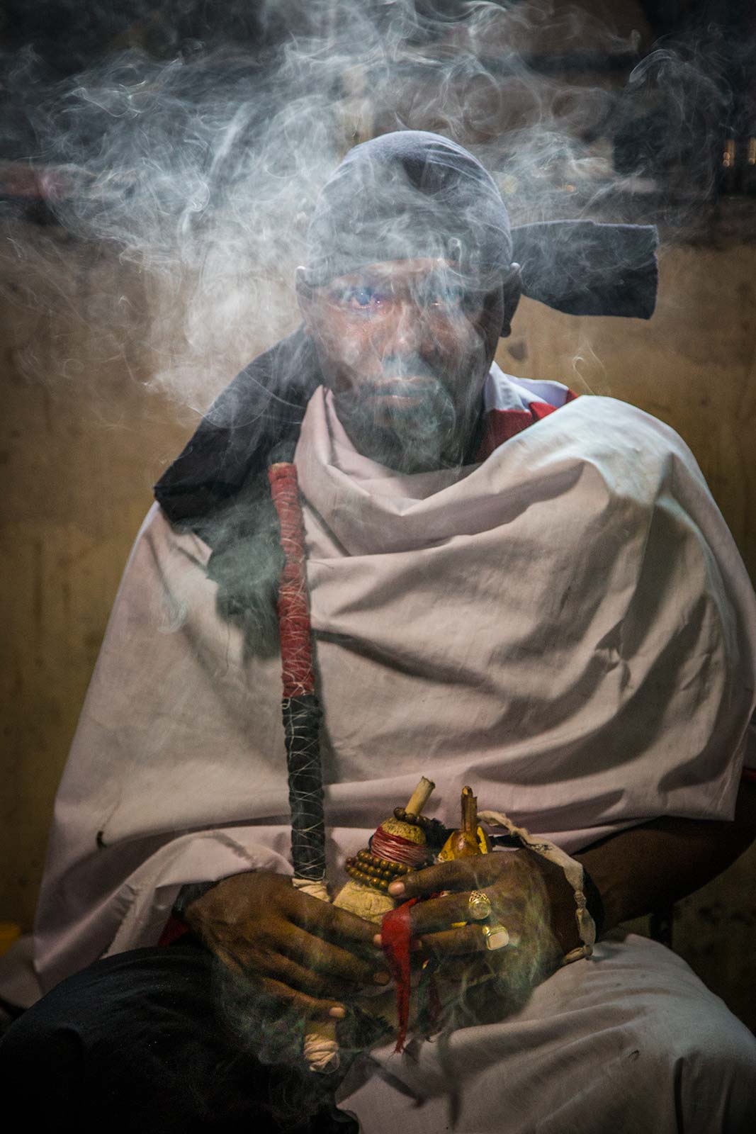 A smoky moody portrait of a  Tanzanian witch doctor performing a ritual 